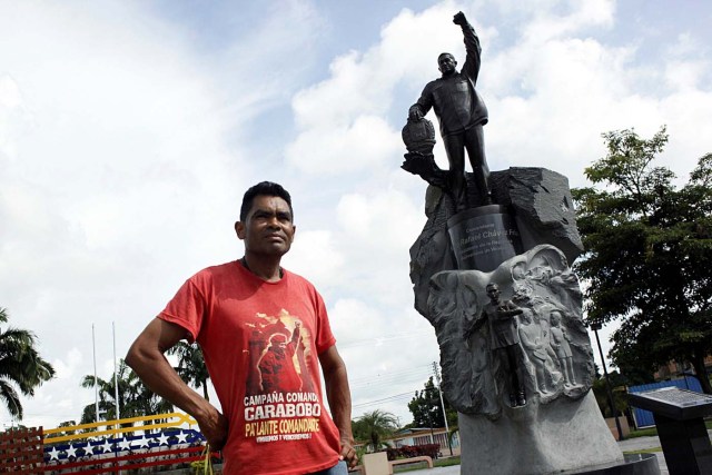 Denny Frias poses for a picture in front of a statue of Venezuela's late President Hugo Chavez in Sabaneta, Venezuela June 13, 2017. Picture taken June 13, 2017. REUTERS/Carlos Eduardo Ramirez