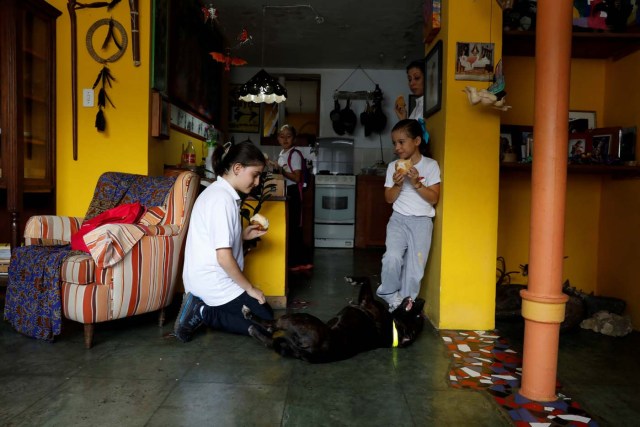 Eloisa Toro (L) and her sisters play with their dog after arriving from school on a day of protests in Caracas, Venezuela June 19, 2017. Picture taken June 19, 2017. REUTERS/Carlos Garcia Rawlins