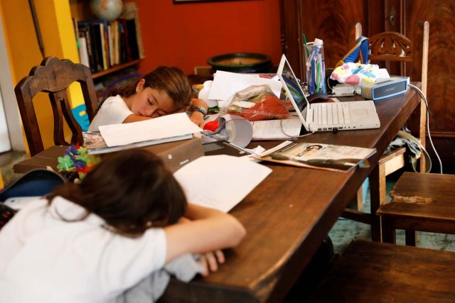 Carlota Valenzuela (L) and her sister Eloisa Toro, fall asleep on the table after arriving from school on a day of protests in Caracas, Venezuela June 7, 2017. Picture taken June 7, 2017. REUTERS/Carlos Garcia Rawlins