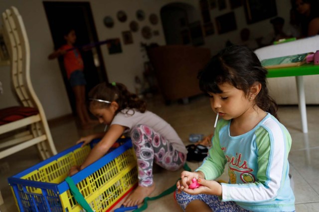 Renata Bonilla (R), plays with her cousins at their grandmother's house on a day of protests in Caracas, Venezuela June 14, 2017. Picture taken June 14, 2017. REUTERS/Carlos Garcia Rawlins
