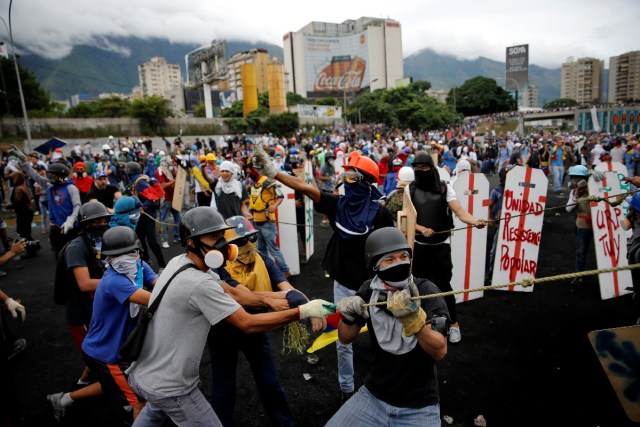 Demonstrators use ropes to take down a fence in the perimeter of an Air Force base while clashing with riot security forces during a rally against Venezuelan President Nicolas Maduro's government in Caracas, Venezuela, June 24, 2017. REUTERS/Ivan Alvarado