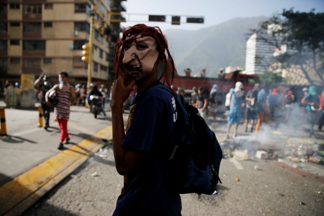 A protester with a mask stands near a roadblock during a rally against Venezuela's President Nicolas Maduro's government in Caracas, Venezuela June 26, 2017. REUTERS/Ivan Alvarado