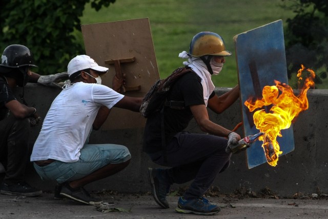 CAR01. CARACAS (VENEZUELA), 30/05/2017.- Manifestantes opositores se enfrentan a la Guardia Nacional Bolivariana durante disturbios tras una marcha opositora hoy, miércoles 31 de mayo de 2017, en Caracas (Venezuela). La Guardia Nacional Bolivariana (GNB, policía militarizada) de Venezuela impidió hoy con chorros de agua y gases lacrimógenos que la marcha convocada por la oposición llegara hasta la Cancillería, ubicada en el centro de Caracas. EFE/CRISTIAN HERNÁNDEZ