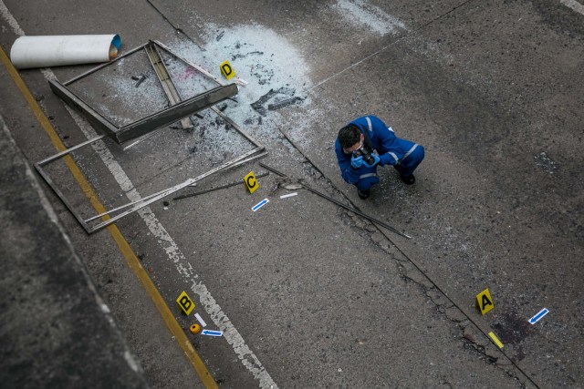 CAR26. CARACAS (VENEZUELA), 08/06/2017 - Trabajadores del Ministerio Público realizan hoy, jueves 8 de junio de 2017, el levantamiento planimétrico en el lugar en el que un joven de 17 años murió durante una protesta opositora, en Caracas (Venezuela). El Ministerio Público venezolano (MP, Fiscalía) cifró hoy en 67 las muertes registradas en hechos violentos relacionados con las protestas a favor y en contra del Gobierno de Nicolás Maduro que sacuden la nación desde hace 69 días. EFE/MIGUEL GUTIÉRREZ