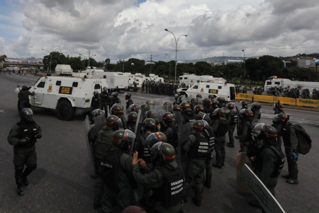 CAR001. CARACAS (VENEZUELA), 19/04/2017.- Miembros de la Guardia Nacional (GNB) intentan detener una manifestación opositora hoy, lunes 19 de junio de 2017, en Caracas (Venezuela). Los cuerpos de seguridad del Estado venezolanos dispersaron hoy con gases lacrimógenos y chorros de agua las marchas de los opositores al Gobierno que salieron desde varios puntos de Caracas e intentaban movilizarse hasta la sede del Consejo Nacional Electoral (CNE), en el centro de la capital. EFE/Miguel Gutiérrez