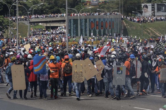 CAR001. CARACAS (VENEZUELA), 19/04/2017.- Manifestantes opositores se enfrentan con miembros de la Guardia Nacional (GNB) durante una protesta hoy, lunes 19 de junio de 2017, en Caracas (Venezuela). Los cuerpos de seguridad del Estado venezolanos dispersaron hoy con gases lacrimógenos y chorros de agua las marchas de los opositores al Gobierno que salieron desde varios puntos de Caracas e intentaban movilizarse hasta la sede del Consejo Nacional Electoral (CNE), en el centro de la capital. EFE/Miguel Gutiérrez