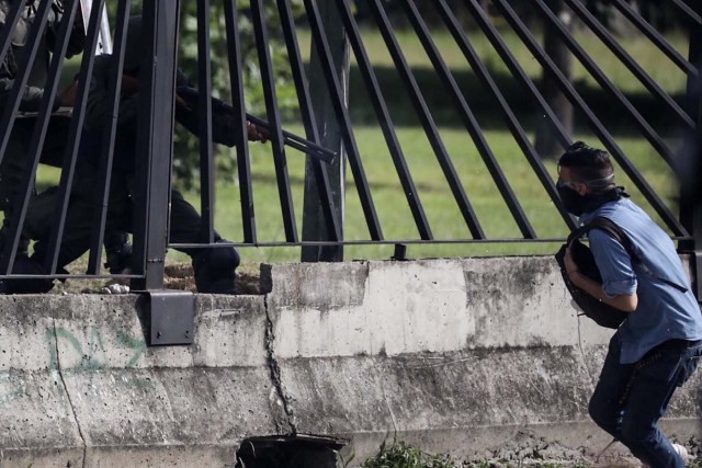 VEN01. CARACAS (VENEZUELA), 22/06/2017.- El joven David José Vallenilla (d), de 22 años, recibe un disparo de un miembro de la Guardia Nacional Bolivariana (GNB) hoy, jueves 22 de junio de 2017, en las inmediaciones de la bases aérea militar La Carlota, en Caracas (Venezuela). El Ministerio Público (MP) de Venezuela informó hoy del fallecimiento de Vallenilla, que recibió un disparo durante una manifestación opositora en Caracas. Con este deceso la Fiscalía cuenta 75 fallecidos según los datos corregidos y actualizados del organismo en sus informes sobre la oleada de protestas que inició el pasado 1 de abril en el país. EFE/Miguel Gutiérrez