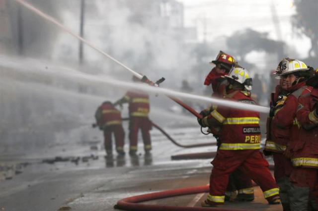 Un grupo de bomberos trata de apagar un incendio en un edificio ocupado por galerías de productos de ferretería hoy, viernes 23 de junio de 2017, en Lima (Perú). Cientos de bomberos voluntarios combaten desde hace más de 20 horas un gran incendio que se desató en un almacén en el centro de Lima, que ha dejado, hasta el momento, 3 heridos y entre 4 y 6 personas que aún no han podido ser rescatadas de la azotea del edificio. EFE/Juan Corominas