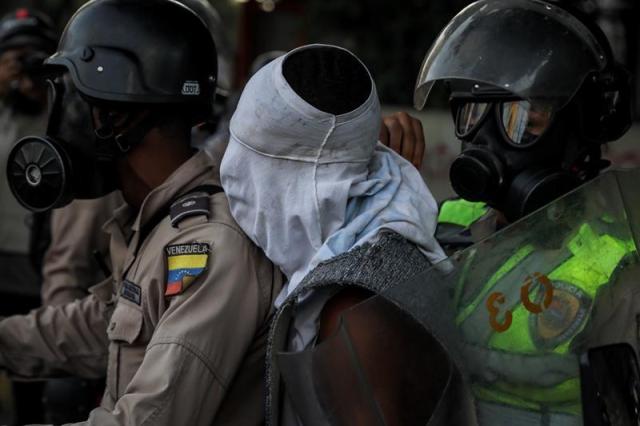 Reporteros gráficos denuncian que los cuerpos de seguridad están cubriendo los rostros de los manifestantes detenidos. Foto: EFE