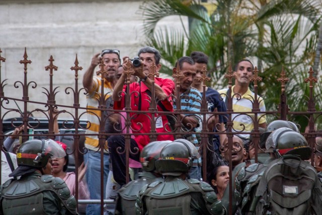 VEN17. CARACAS (VENEZUELA), 27/06/2017.- Un grupo de personas se agolpa frente a la entrada del Palacio Legislativo, hoy, martes 27 de junio de 2017, en Caracas (Venezuela). El presidente del Parlamento venezolano, el opositor Julio Borges, aseguró hoy que grupos civiles armados atacaron la sede del Legislativo, luego de que se produjera un choque entre algunos diputados y miembros de la Guardia Nacional Bolivariana (GNB, policía militarizada) dentro de la institución. EFE/STR