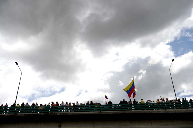 Opposition activists protest against the government of President Nicolas Maduro, at the Francisco Fajardo highway in Caracas, on July 1, 2017. Venezuela marks three months of violent protests within a political and economic crisis with protesters demanding President Nicolas Maduro's resignation and new elections.  / AFP PHOTO / Federico Parra
