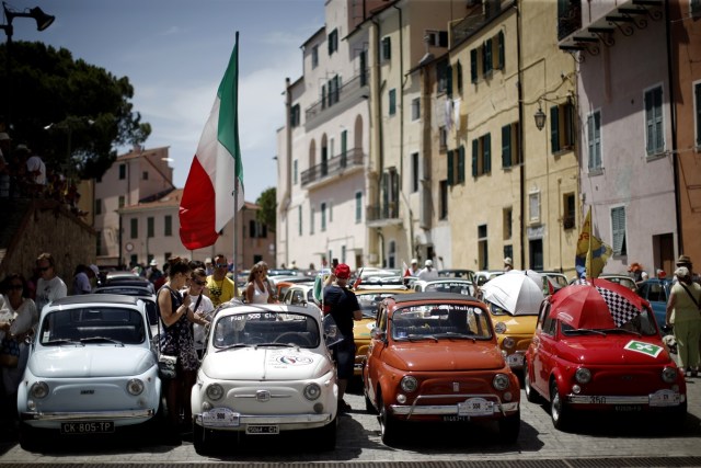People take part at the 34th International Rally of Fiat 500 Club Italia for the 60th anniversary of this car on July 8, 2017, in Garlenda, near Genoa.   More than 1200 cars came from Europe to take part at the 34 rally of Garlenda to celebrate the 60th anniversary of the Fiat 500.  / AFP PHOTO / Marco BERTORELLO