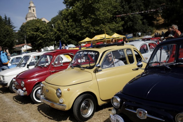 People take part in the 34th International Rally of Fiat 500 Club Italia for the 60th anniversary of this car on July 8, 2017, in Garlenda, near Genoa.   More than 1200 cars came from Europe to take part at the 34 rally of Garlenda to celebrate the 60th anniversary of the Fiat 500.  / AFP PHOTO / Marco BERTORELLO
