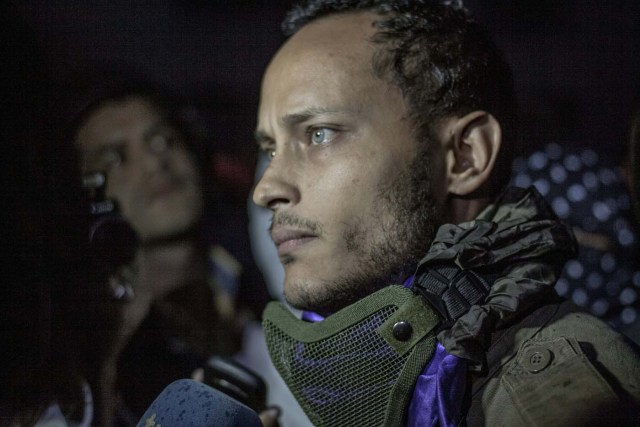 Venezuelan police officer Oscar Perez participates in an anti-government protest in Caracas on July 13, 2017. Perez, who attacked the headquarters of the Supreme Court of Justice with hand grenades thrown from a helicopter, appeared unexpectedly this Thursday at an opposers' rally and after issuing a brief statement fled quickly on a motorcycle. / AFP PHOTO / INAKI ZUGASTI