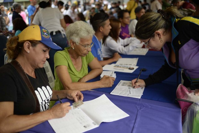A woman marks her ballot on July 16, 2017 in Caracas, in an opposition-organized vote to measure public support for President Nicolas Maduro's plan to rewrite the constitution, against a backdrop of worsening political violence. The authorities have refused to greenlight a vote that has been presented as an act of civil disobedience and supporters of Maduro are boycotting it. So voters seemed set to reject the president's controversial plan. / AFP PHOTO / FEDERICO PARRA