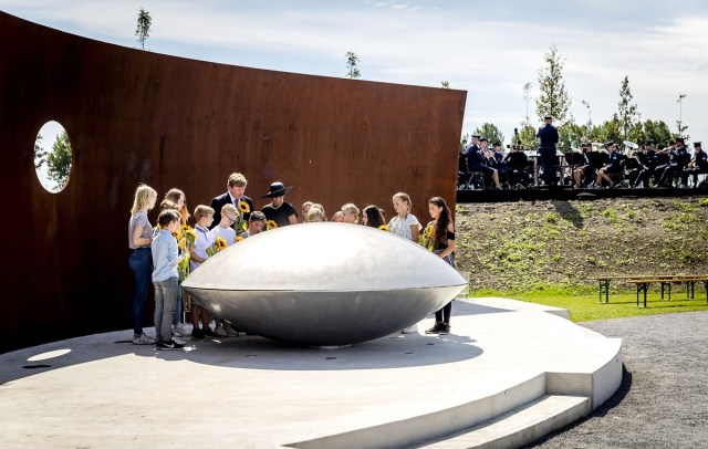 Dutch King Willem-Alexander (C, left) and Queen Maxima (C) attend the unvealing of the National Monument for the MH17 victims in Vijfhuizen, on July 17, 2017. Three years after Flight MH17 was shot down by a missile over war-torn Ukraine, more than 2,000 relatives gather to unveil a "living memorial" to their loved ones. A total of 298 trees have been planted in the shape of a green ribbon, one for each of the victims who died on board the Malaysia Airlines flight en route from Amsterdam to Kuala Lumpur. / AFP PHOTO / ANP / Remko de Waal / Netherlands OUT
