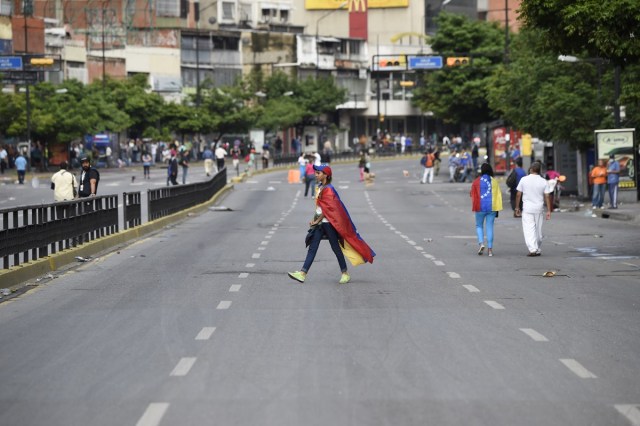 An avenue looks void of vehicles as demonstrators block an avenue during an anti-government protest in Caracas, on July 20, 2017. A 24-hour nationwide strike got underway in Venezuela Thursday, in a bid by the opposition to increase pressure on beleaguered leftist President Nicolas Maduro following four months of deadly street demonstrations. / AFP PHOTO / JUAN BARRETO