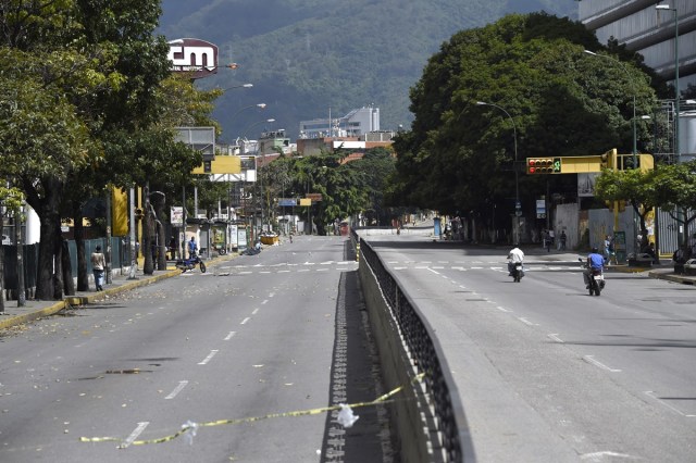 An avenue looks void of vehicles during a general strike in Caracas, on July 20, 2017. A 24-hour nationwide strike got underway in Venezuela Thursday, in a bid by the opposition to increase pressure on beleaguered leftist President Nicolas Maduro following four months of deadly street demonstrations. / AFP PHOTO / JUAN BARRETO