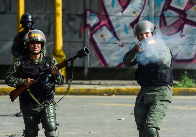 Bolivarian National Guard members clash with demonstrators during an anti-government protest in Caracas, on July 20, 2017. A 24-hour nationwide strike got underway in Venezuela Thursday, in a bid by the opposition to increase pressure on beleaguered leftist President Nicolas Maduro following four months of deadly street demonstrations. / AFP PHOTO / RONALDO SCHEMIDT