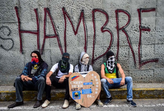 Opposition activists are pictured next to the site where young activist Neomar Lander was mortally wounded during clashes with riot police, during a protest in Caracas, on July 24, 2017 Venezuela's angry opposition is pushing for a boycott of an upcoming vote that it dismisses as a ploy by President Nicolas Maduro to cling to power. / AFP PHOTO / RONALDO SCHEMIDT