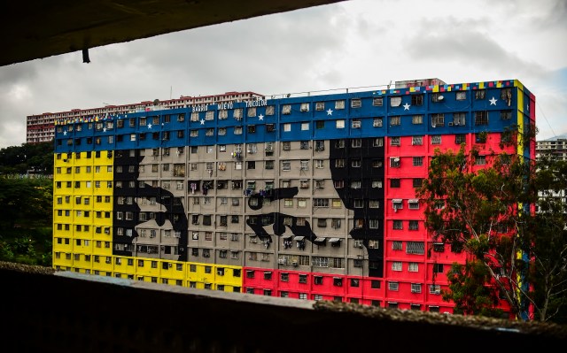 Picture of a building depicting the eyes of late Venezuelan president Hugo Chavez at "23 de Enero" neighbourhood in Caracas near the "Cuartel de la Montaña" museum where his body rests, taken on July 28, 2017 on the 63rd anniversary of his birth. The opposition called fresh nationwide demonstrations in defiance of a new government ban on rallies ahead of Sunday's controversial vote to elect a body to rewrite the constitution. / AFP PHOTO / Ronaldo SCHEMIDT