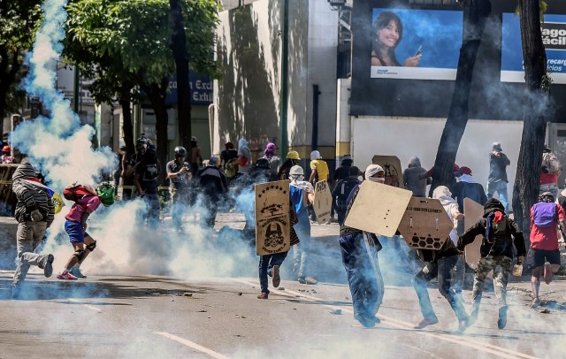 Los activistas de la oposición chocan con la policía antidisturbios durante una protesta contra el gobierno del presidente Nicolas Maduro y en desafío a una nueva prohibición de manifestaciones antes del controvertido voto del domingo en Caracas el 28 de julio de 2017. Venezuela se lanzó el viernes a un enfrentamiento entre manifestantes antigubernamentales y fuerzas de seguridad, mientras el número de víctimas mortales de meses de manifestaciones contra el presionado presidente Nicolás Maduro aumentó, al igual que la preocupación internacional por la espiral de violencia.   / AFP FOTO / JUAN BARRETO