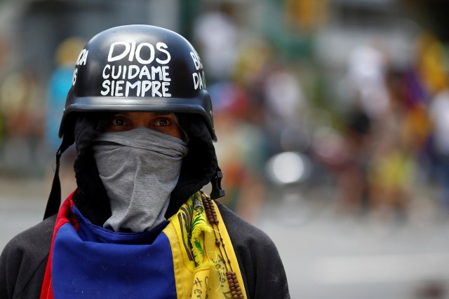 Un manifestante que lleva un casco con el texto "Dios, cuídame siempre" asiste a una manifestación contra el gobierno del presidente venezolano Nicolás Maduro en Caracas, Venezuela el 1 de julio de 2017. REUTERS / Christian Veron