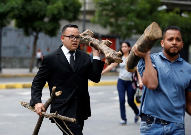 Opposition supporters carry chunks of branches to block a street while rallying against Venezuela's President Nicolas Maduro's government, in Caracas, Venezuela July 4, 2017. REUTERS/Andres Martinez Casares