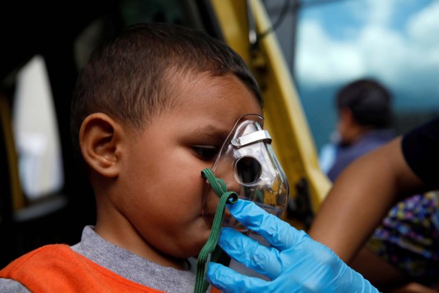 A child gets medical attention outside a shopping mall after smoke from tear gas fired by security forces got inside of it during clashes at a rally against Venezuelan President Nicolas Maduro's government in Caracas, Venezuela, July 6, 2017. REUTERS/Carlos Garcia Rawlins