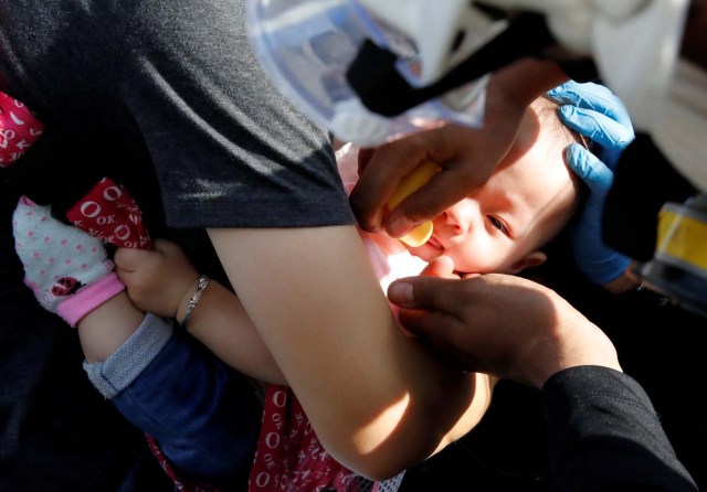 A baby gets medical attention outside a shopping mall after smoke from tear gas fired by security forces got inside of it during clashes at a rally against Venezuelan President Nicolas Maduro's government in Caracas, Venezuela, July 6, 2017. REUTERS/Carlos Garcia Rawlins