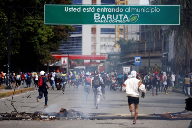 Demonstrators run past a barricade during clashes at a rally against Venezuelan President Nicolas Maduro's government in Caracas, Venezuela, July 6, 2017. REUTERS/Andres Martinez Casares