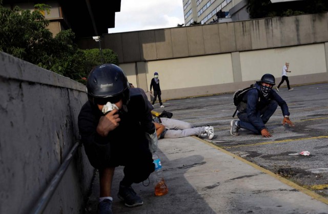 Demonstrators take cover during clashes with security forces at a rally against Venezuelan President Nicolas Maduro's government in Caracas, Venezuela, July 6, 2017. REUTERS/Andres Martinez Casares