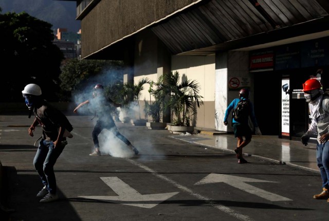 A demonstrator throws back a tear gas canister during clashes with security forces at a rally against Venezuelan President Nicolas Maduro's government in Caracas, Venezuela, July 6, 2017. REUTERS/Andres Martinez Casares