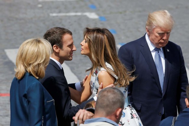 French President Emmanuel Macron kisses U.S. First Lady Melania Trump as his wife Brigitte Macron looks on and next to U.S. President Donald Trump at the end of the traditional Bastille Day military parade on the Champs-Elysees in Paris, France, July 14, 2017. REUTERS/Gonzalo Fuentes
