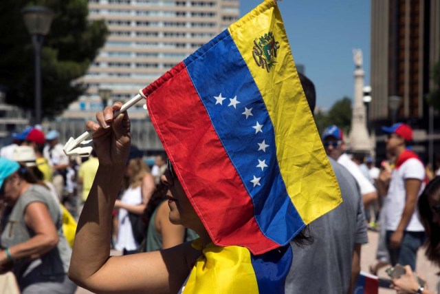 A woman holds a Venezuelan national flag during an unofficial plebiscite against Venezuela's President Nicolas Maduro's government in Madrid, Spain, July 16, 2017. REUTERS/Juan Medina