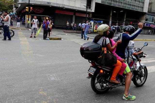 A motorcyclist lifts a rope to pass a street blockage, during a protest against Venezuelan President Nicolas Maduro's government in Caracas, Venezuela July 19, 2017. REUTERS/Carlos Garcia Rawlins