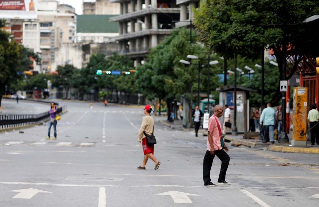 People walk along empty roads during a strike called to protest against Venezuelan President Nicolas Maduro's government in Caracas, Venezuela, July 20, 2017. REUTERS/Andres Martinez Casares