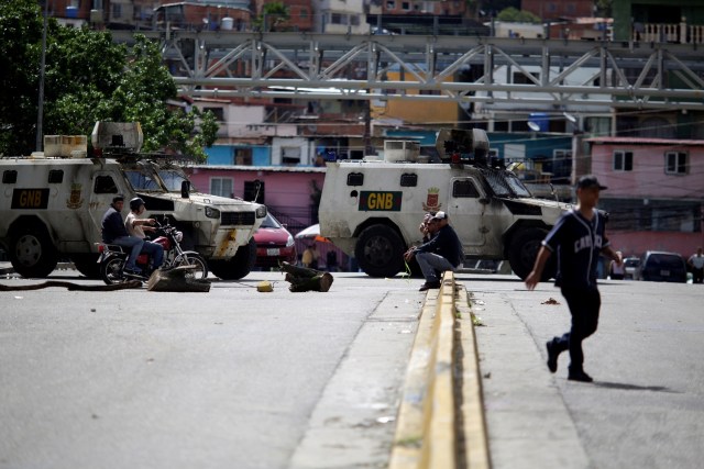 La gente pasa por una calle bloqueada por las fuerzas de seguridad durante una huelga convocada para protestar contra el gobierno del presidente venezolano Nicolás Maduro en Caracas, Venezuela, 20 de julio de 2017. REUTERS / Marco Bello