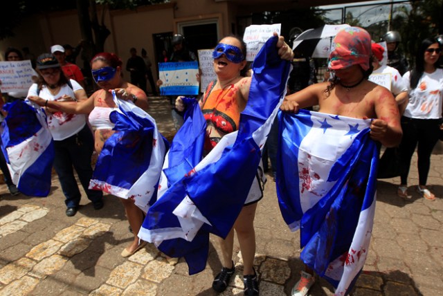 Members of a feminist group hold flags of Honduras during a protest against gender violence outside the presidential house in Tegucigalpa, Honduras, July 20, 2017. REUTERS/Jorge Cabrera TEMPLATE OUT
