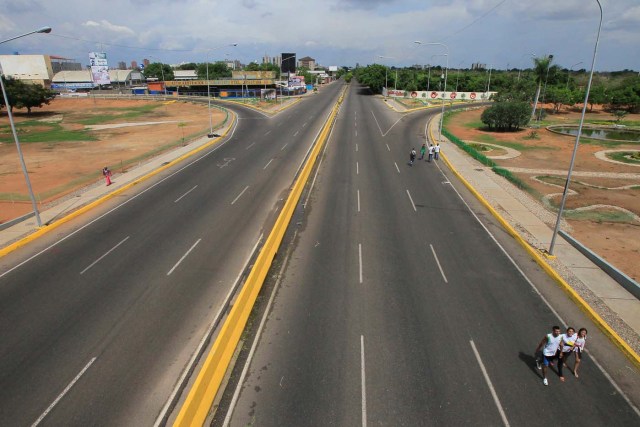 People walk on an empty highway during a strike called to protest against Venezuelan President Nicolas Maduro's government in Maracaibo, Venezuela July 20, 2017. REUTERS/Isaac Urrutia