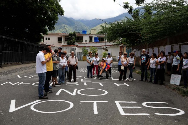Opposition supporters attend a rally against the National Constituent Assembly, outside a school where a polling center will be established for a Constitutional Assembly election next Sunday, in Caracas, Venezuela July 24, 2017. The paint on the street reads "Do not vote". REUTERS/Marco Bello