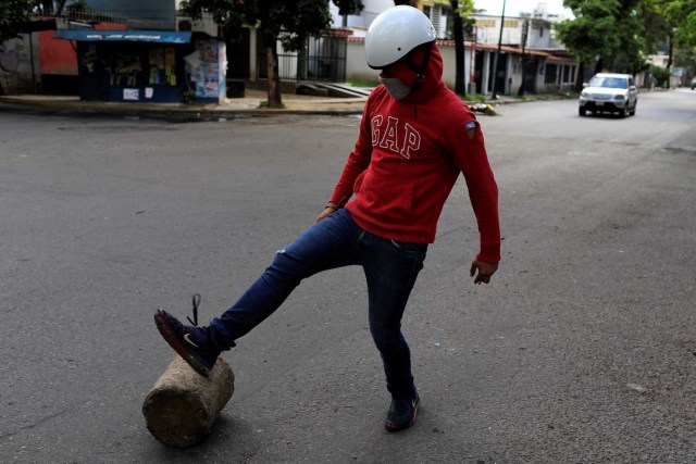 A demonstrator moves a piece of wood to prepare a barricade during a strike called to protest against Venezuelan President Nicolas Maduro's government in Caracas, Venezuela, July 26, 2017. REUTERS/Marco Bello
