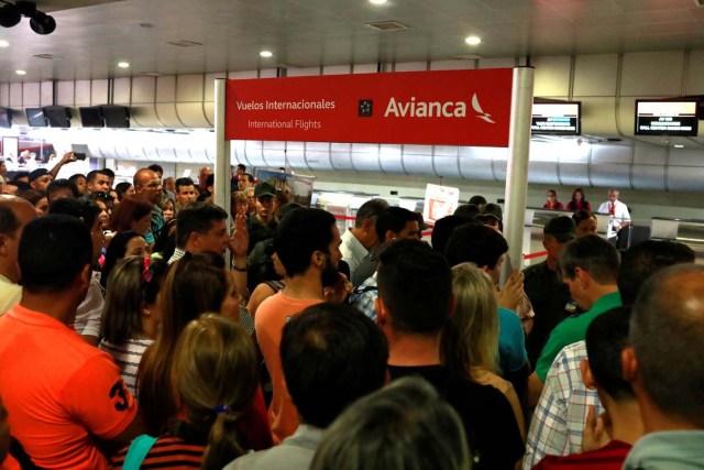 People congregate in front of counters of Avianca airline at the Simon Bolivar airport in Caracas, Venezuela July 27, 2017. REUTERS/Marco Bello