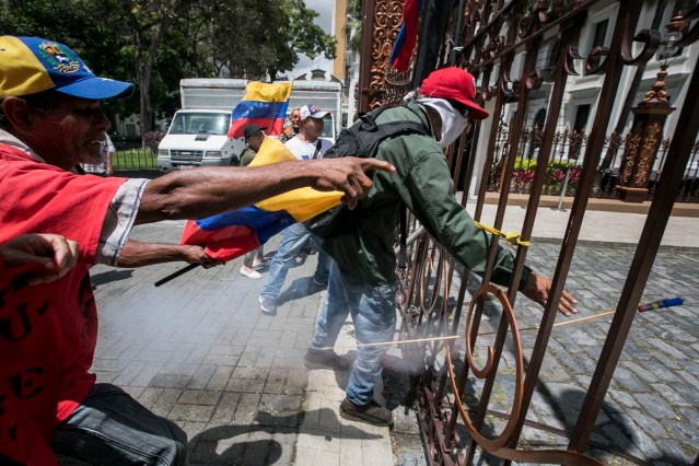 CAR12 - CARACAS (VENEZUELA), 05/07/2017 - Simpatizantes del Gobierno manifiestan en inmediaciones de la Asamblea Nacional hoy, miércoles 5 de mayo de 2017, en Caracas (Venezuela). Un grupo de simpatizantes del Gobierno venezolano irrumpió hoy por la fuerza en la Asamblea Nacional (AN, Parlamento), de mayoría opositora, y causaron heridas a algunos diputados que se encontraban en el recinto para una sesión en conmemoración del Día de la Independencia en el país. EFE/MIGUEL GUTIÉRREZ