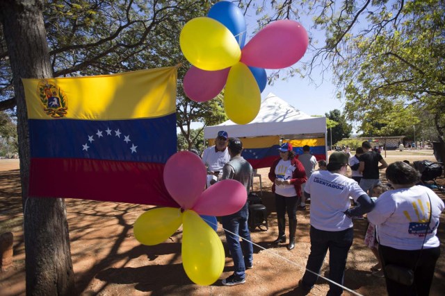 BRA106. BRASILIA (BRASIL), 16/07/2017.- La comunidad venezolana de Brasilia vota en la calle la consulta popular impulsada por los opositores del presidente Nicolás Maduro ante la negativa del Ayuntamiento a que se realizase en un centro cívico por la falta de permisos hoy, domingo 16 de julio de 2017, en Brasilia (Brasil). La oposición venezolana lanza este domingo su mayor desafío al Gobierno del presidente Nicolás Maduro con la convocatoria de una consulta calificada de ilegal desde el oficialismo en la que espera que el pueblo se pronuncie masivamente contra el proceso constituyente impulsado por el chavismo. EFE/Joédson Alves