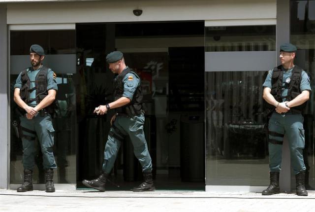 Foto: Agentes de la Guardia Civil custodian el acceso principal de la sede de la Federación Española de Fútbol, en la localidad madrileña de Las Rozas, donde se están produciendo registros en el marco de una operación anticorrupción ordenada por la Audiencia Nacional en la que ha sido detenido el presidente de la institución, Ángel María Villar. Además de Villar, las fuentes apuntan que ha sido detenido su hijo Gorka, así como Juan Padrón, vicepresidente económico de la federación, en un operativo en el que se esperan una decena de arrestos. Los delitos por los que han sido detenidos son administración desleal, apropiación indebida, corrupción entre particulares y falsedad documental, todo ello en relación con la organización de partidos internacionales. EFE/Chema Moya