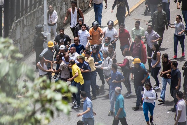 VEN106. CARACAS (VENEZUELA), 20/07/2017 - Un manifestante es retenido por los trabajadores del canal VTV hoy, jueves 20 de julio de 2017, en Caracas (Venezuela). Miembros de la GNB comenzaron a dispersar las protestas en la vía pública de varias zonas de Caracas que desarrollan los opositores en el marco de un "paro cívico nacional" de 24 horas. El presidente de Venezuela, Nicolás Maduro, pidió hoy a la justicia del país "actuar inmediatamente" contra el alcalde opositor Carlos Ocariz, a quien responsabilizó de un "ataque" a la planta televisiva estatal VTV, al tiempo que ordenó "capturar a todos los terroristas" implicados en el suceso. EFE/NATHALIE SAYAGO