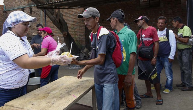 Venezuelans get food at the Casa de Paso Divina Providencia refuge in Cucuta, Colombia on July 31, 2017. The United States, Mexico, Colombia, Peru and other nations said they did not recognize the results of the election Sunday of a new "Constituent Assembly" superseding Venezuela's legislative body, the opposition-controlled National Assembly. / AFP PHOTO / SCHNEYDER MENDOZA