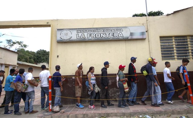 Venezuelans line up to get food at the Casa de Paso Divina Providencia refuge in Cucuta, Colombia on July 31, 2017. after crossed the Simon Bolivar international bridge from San Antonio del Tachira, Venezuela towards Cucuta , who must show the immigration card and the Venezuelan citizenship card to be able to access this assistance,  by different companies and communities in the country / AFP PHOTO / SCHNEYDER MENDOZA