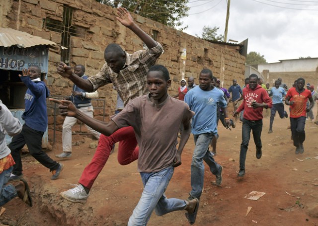 Protestors run away after riot police fired live rounds in the Kibera slum in Nairobi, on August 12, 2017. Three people, including a child, have been shot dead in Kenya in opposition protests which raged overnight after the hotly disputed election victory of President Kenyatta. Demonstrations and running battles with police broke out in Nairobi slums after anger in opposition strongholds against an election that losing candidate Raila Odinga claims was massively rigged. / AFP PHOTO / CARL DE SOUZA